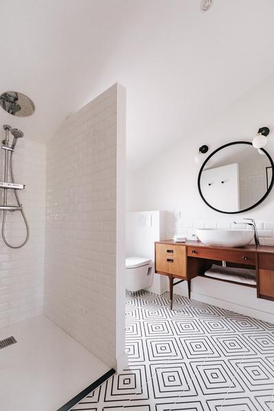 Salle d'eau avec douche à l'italienne, toilette, meuble avec lavabo.