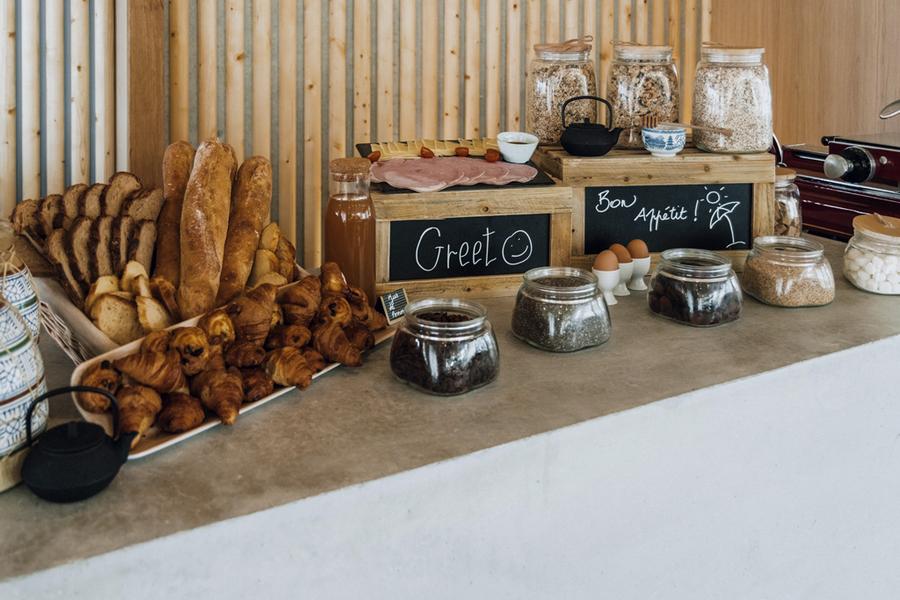 Le buffet du petit-déjeuner avec des cérales, des viennoiseries, du pain, des oeufs, de la charcuterie, du fromage.