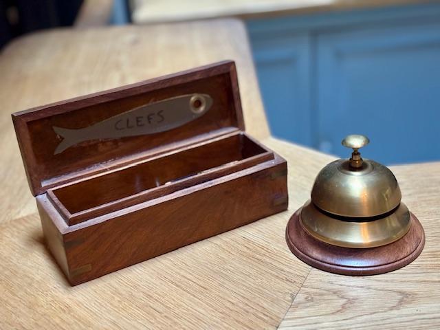 Une sonnette de comptoir avec une petite boite à clefs.