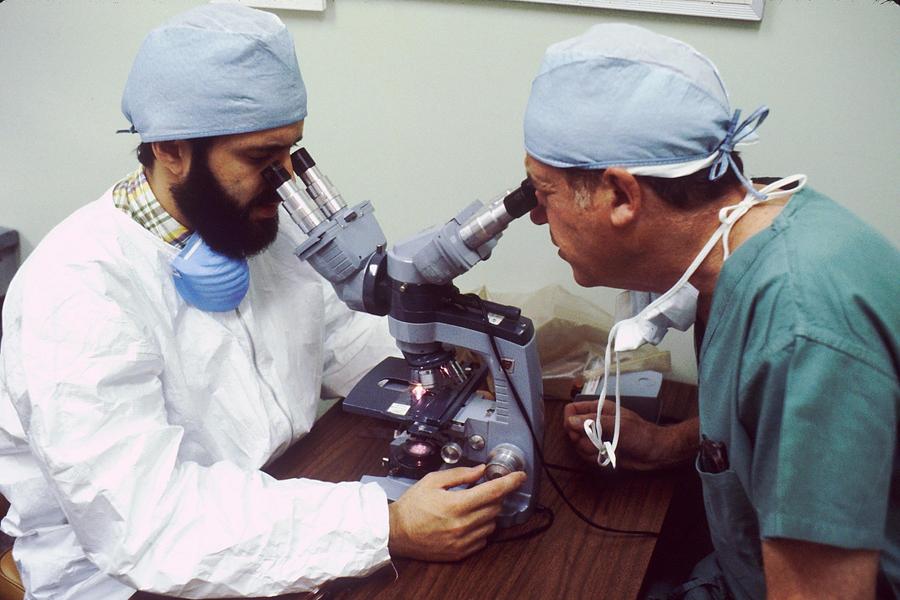 Deux biologistes regardant dans un microscope