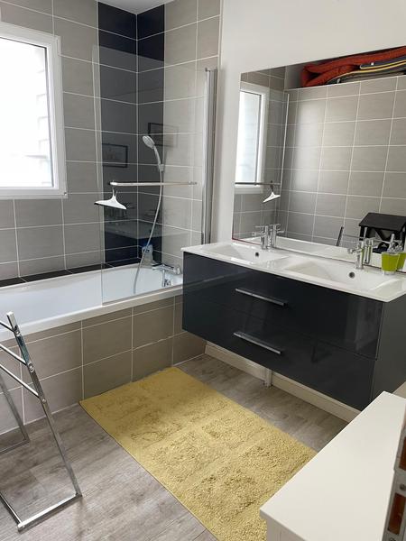 Une salle de bain avec baignoire, double vasque.