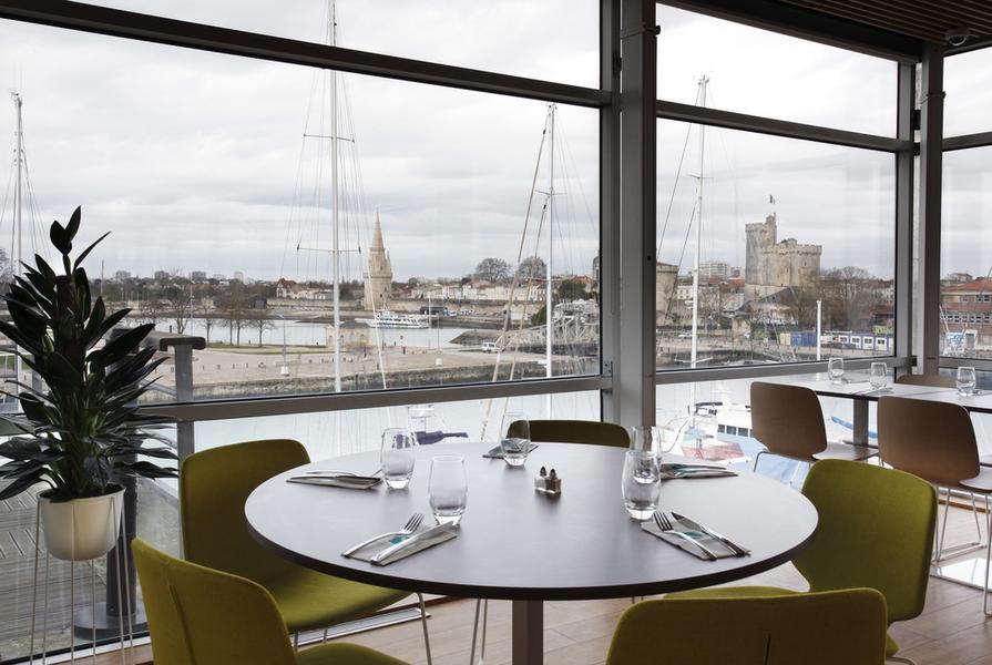 une table ronde ayant vue sur le porte et les Tours de la Rochelle.