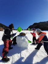 Les enfants construisent un bonhomme de neige