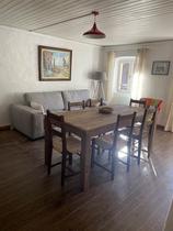 Séjour lumineux avec table à manger, canapé, ameublement bois, fenêtre