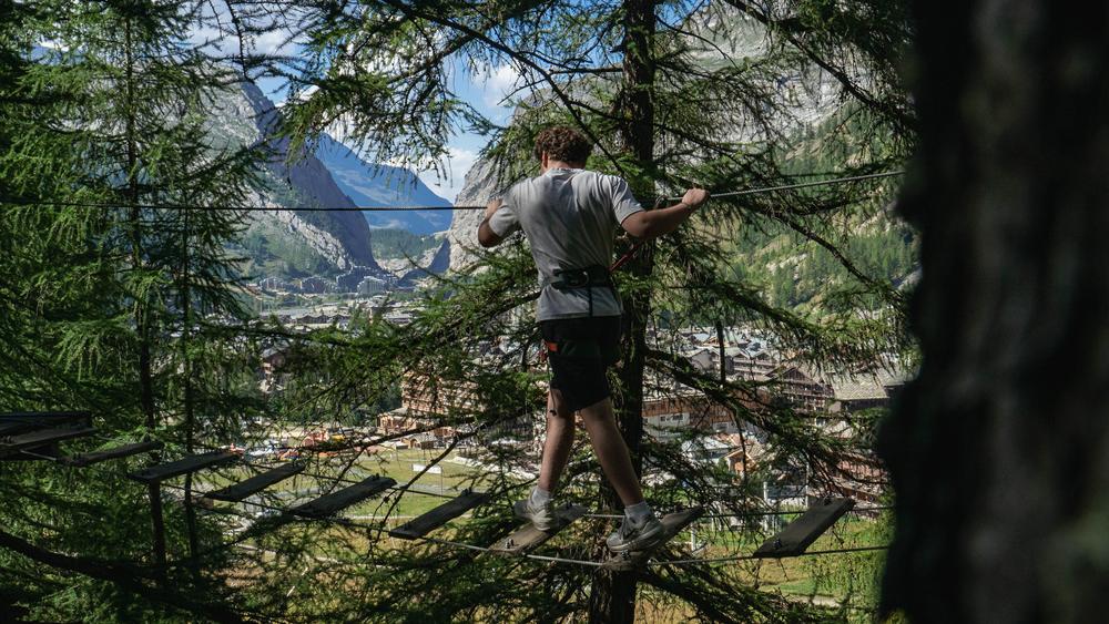 Vue sur le village de Val d'Isère avec une personne sur la plateforme - Accrobranche Val Aventure à Val d'Isère
