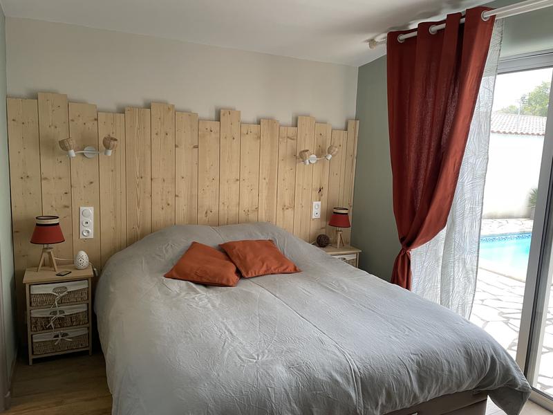 Une chambre avec un lit double, donnant sur la piscine.