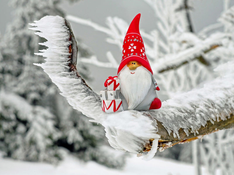 Petit Père Noël en décoration posé sur un morceau de bois