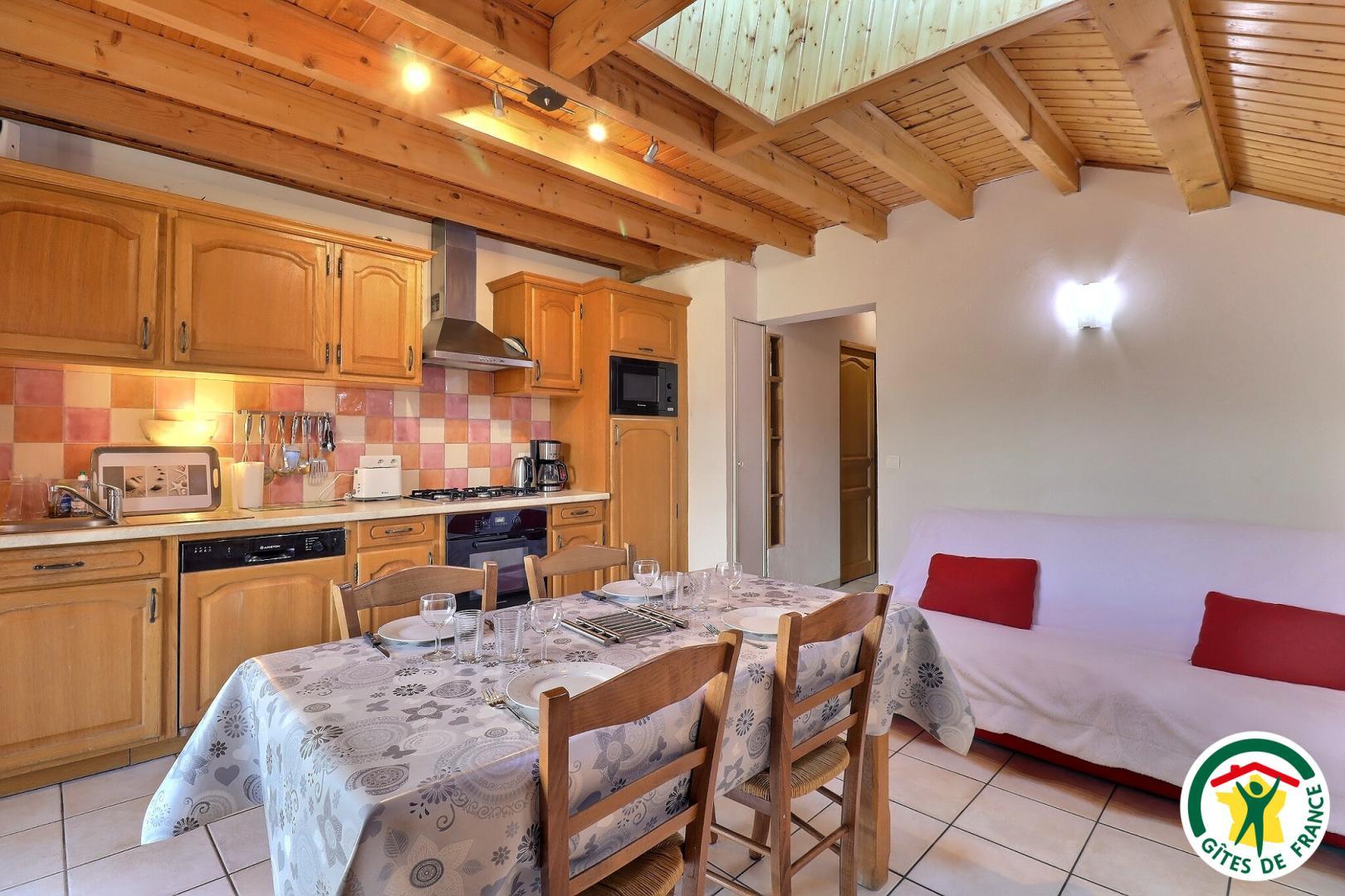 Pièce à vivre : canapé clic-clac (1x140), TV, espace repas et cuisine équipée.
Accès au balcon/terrasse depuis cette pièce.