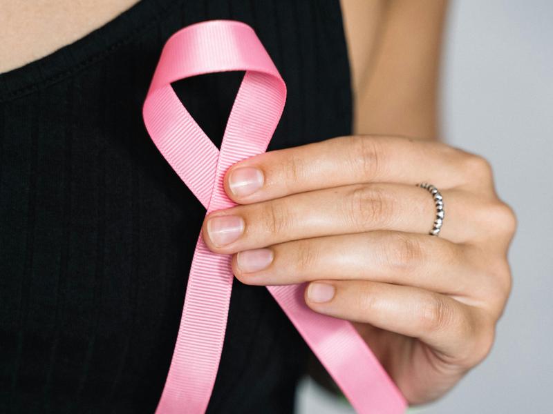 Une femme tenant un ruban rose