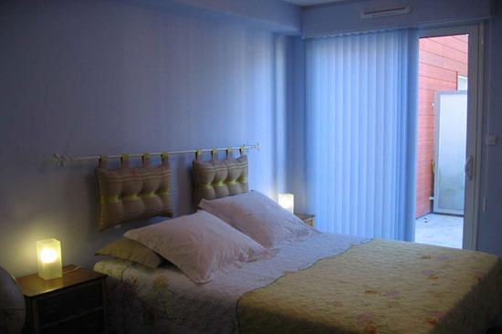 Chambre avec un lit double, donnant sur le balcon.