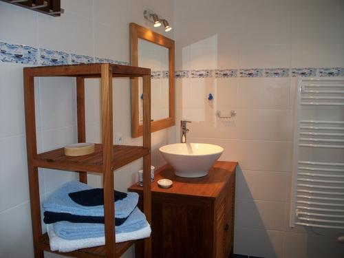 Un évier, un sèche serviette, une tour de rangement.
