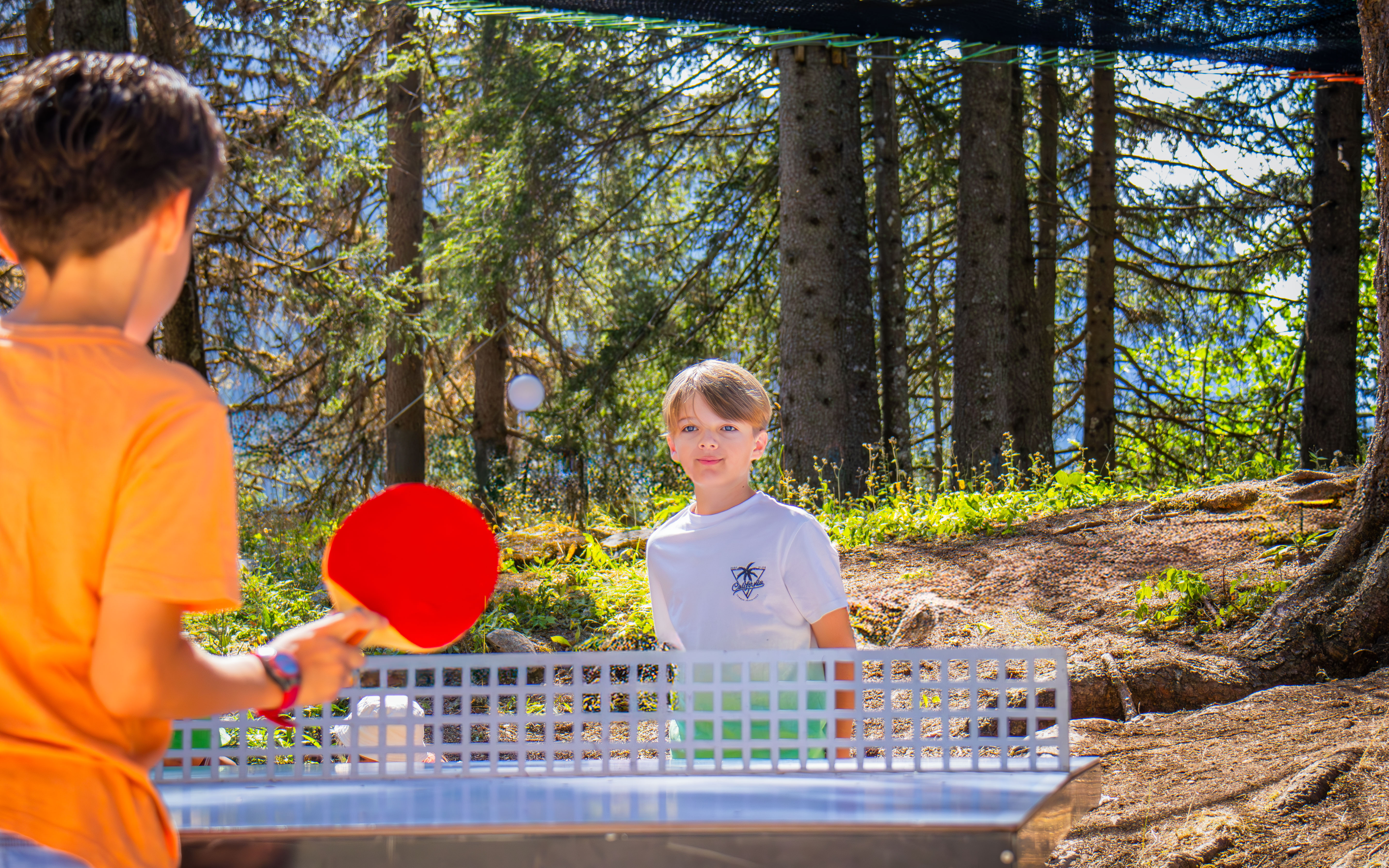 Two boys playing table tennis against each other