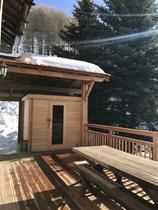 Terrasse en bois ensoleillée avec cabane, banc
