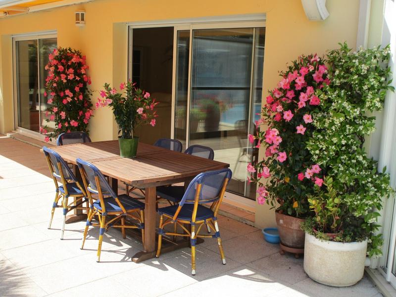 Terrasse fleurie avec table et chaises de jardin