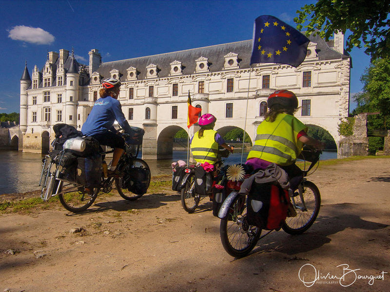 Family of 4 passing near one of the Loire castles by bike.