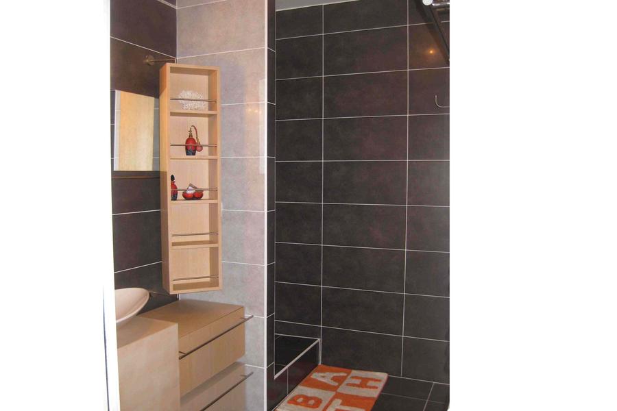 Salle d'eau avec douche et meuble de lavabo.