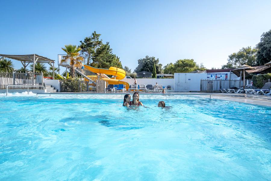 Une femme et deux petites filles dans la piscine.