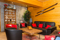 Salon confortable avec joli vaisselier et vieux skis en bois pour la décoration