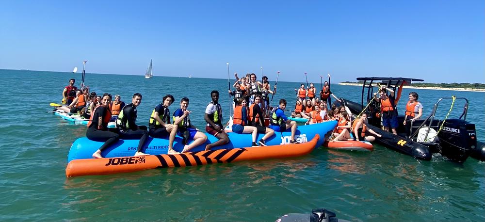 une quarantaine de personnes sur des bouées tractées banane et des paddles géants.
