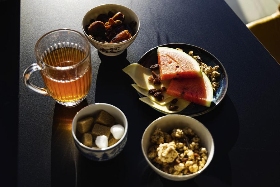 Une tasse de thé, du sucre, des tranches de pastèque, des fruits secs.