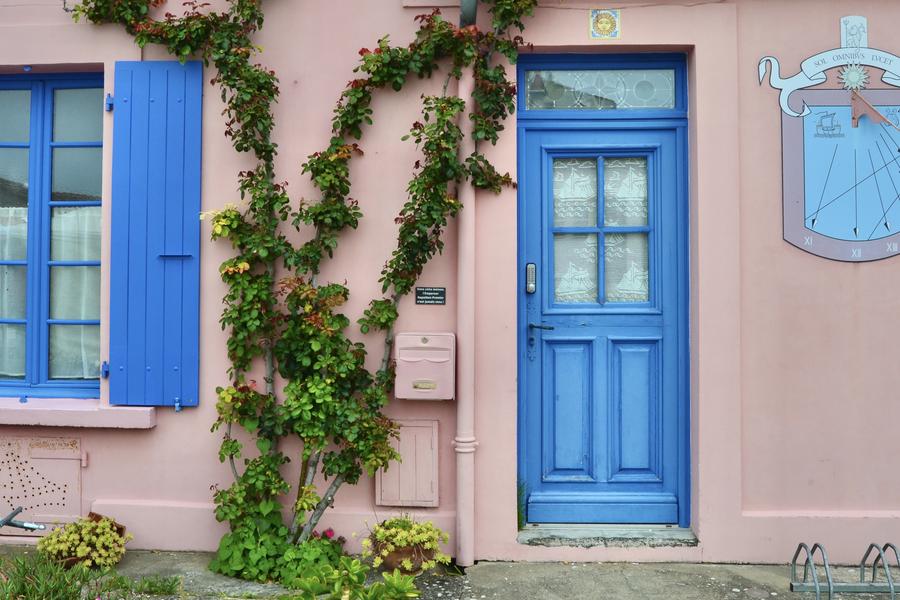 La porte et le volet bleus d'une maison.
