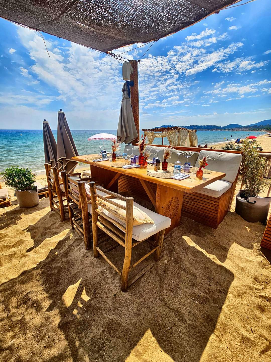 Table en bois dressée sur le sable face à la mer à La Plage