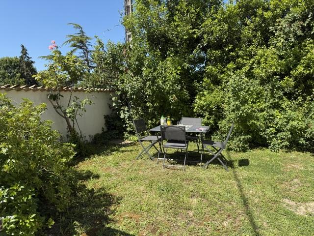 jaridn avec une table métallique et 4 chaises.