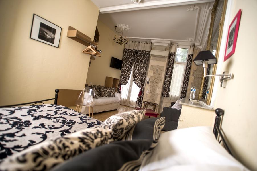 Une chambre avec un lit double, un canapé dans le fond de la chambre.
