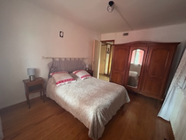 Camera luminosa con parquet in legno e letto matrimoniale. Armadio a 3 porte con uno specchio al centro