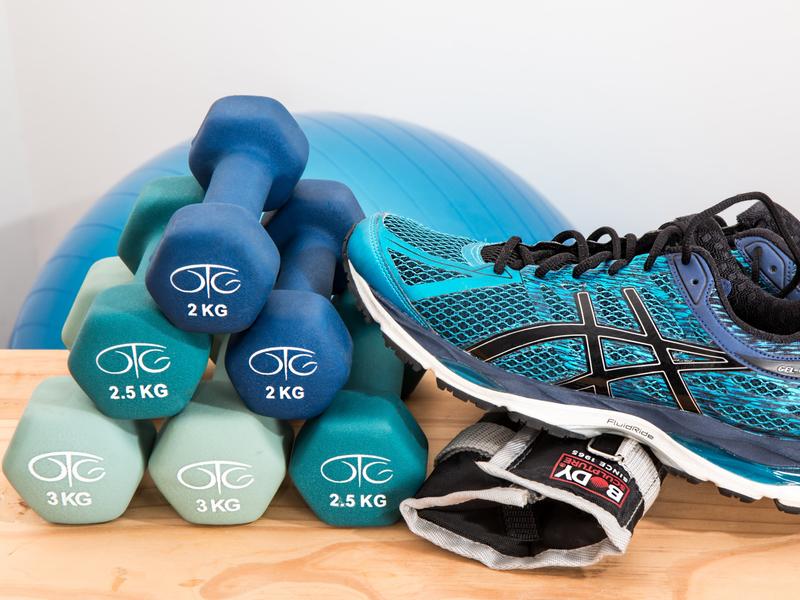 Des baskets sont posées sur une table avec des haltères