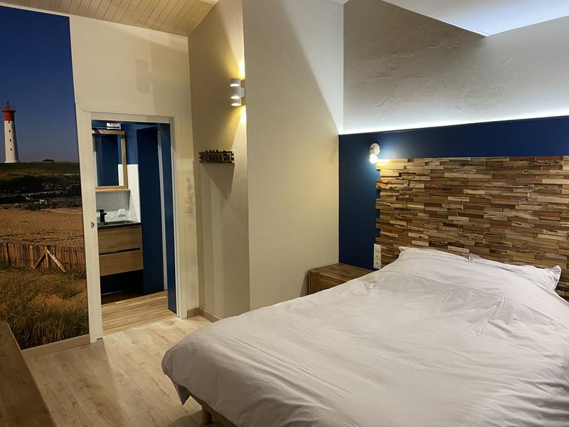 Une chambre sur le thème de l'ile d'Aix, avec un lit double, donnant sur une salle d'eau.