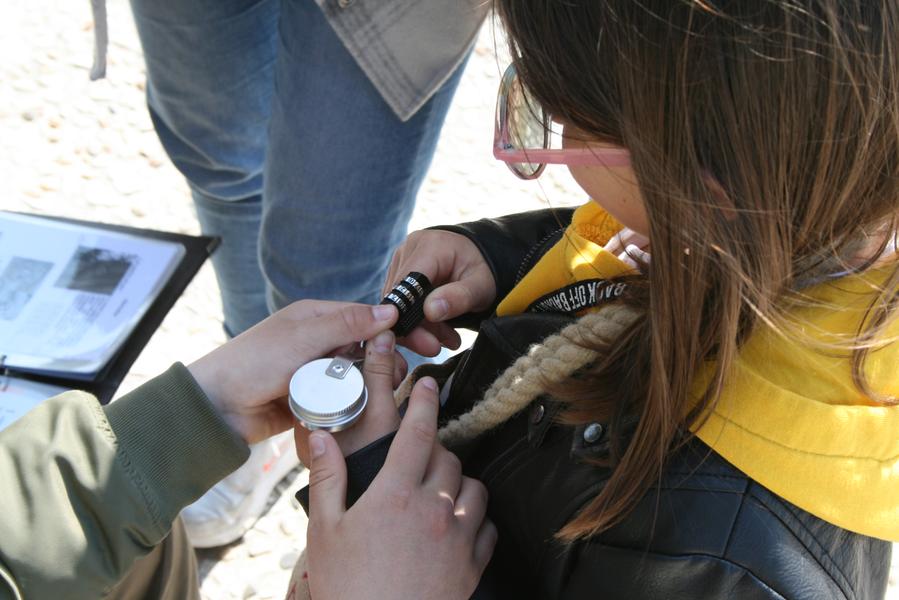 Une petite fille essayant d'ouvrir un cadenas à code.