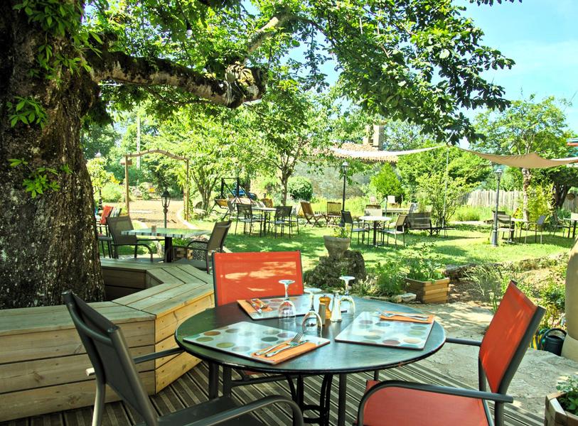 Tables en terrasse dans un jardin ombragé et paisible