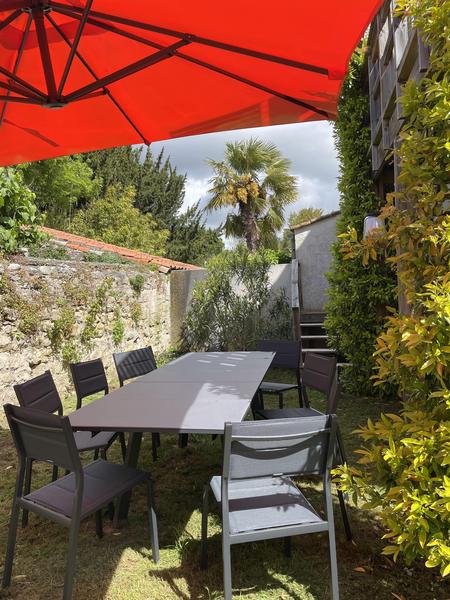 Jardin ouest avec grande table de jardin, chaises et parasol