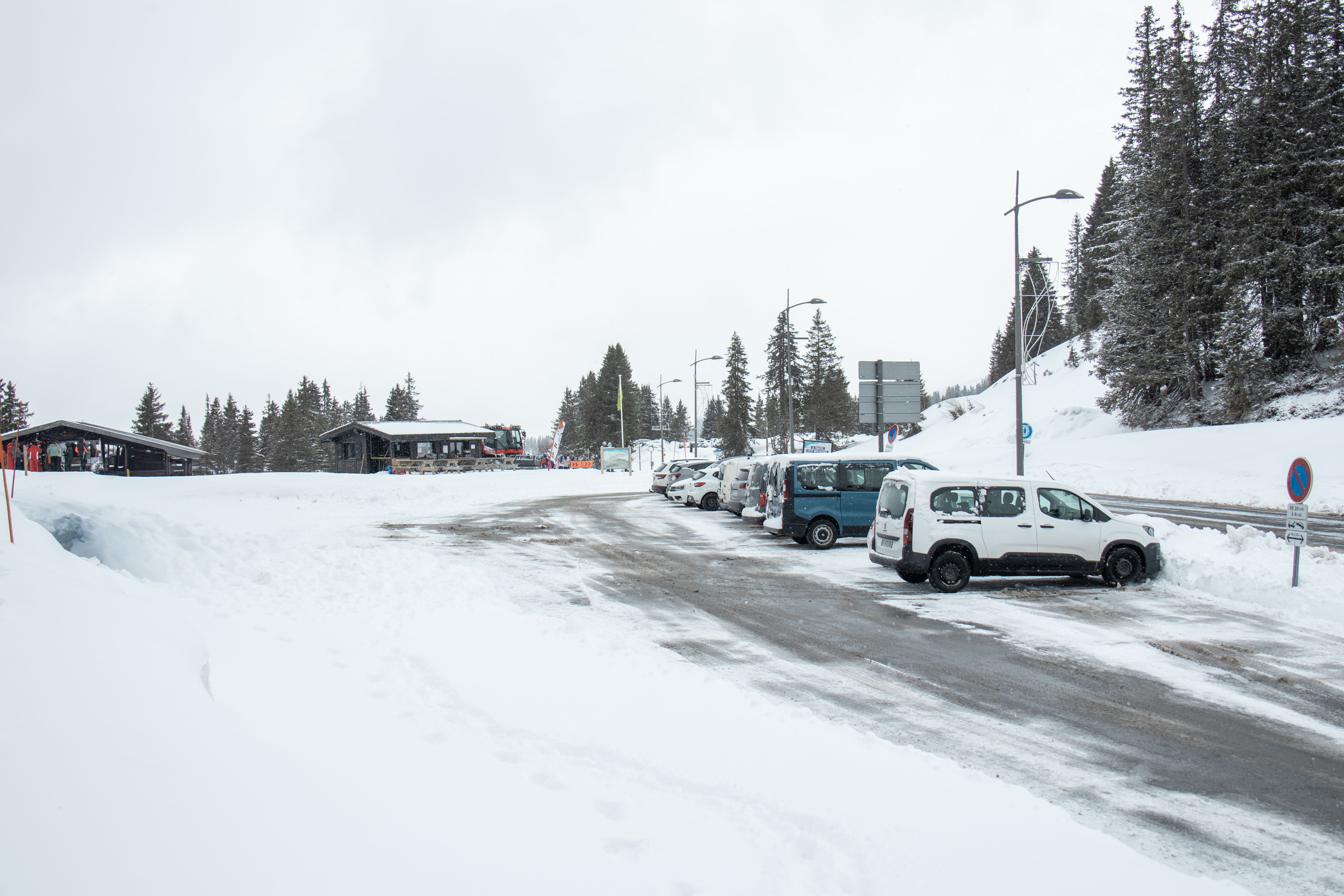 Overview of the Col de Pierre Carrée car park in winter, with a view of the chalet