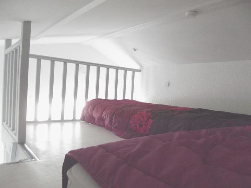 Mezzanine avec deux lits simples au sol.