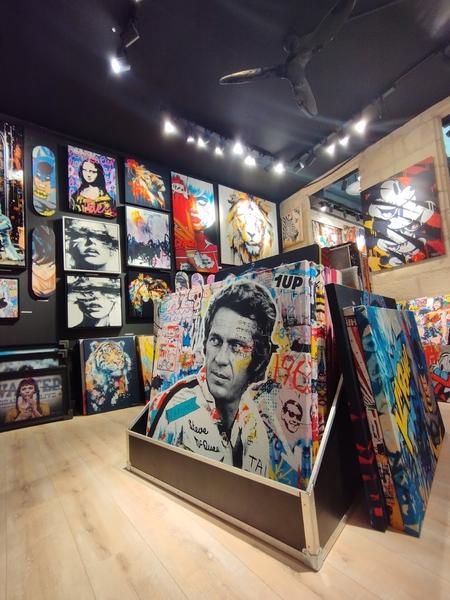 L'intérieur de la boutique, des tableaux au sol et aux murs.