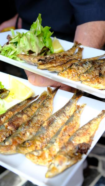 Deux assiettes de sardines grillées.