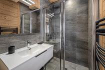 Salle de bains avec douche à l'italienne, grande vasque avec meuble, miroir et sèche serviettes