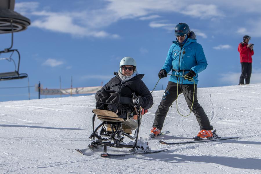 Un moniteur de ski donnant un cours de Snow'kart à une personne