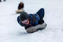 Jeune garçon dévalant une piste de luge