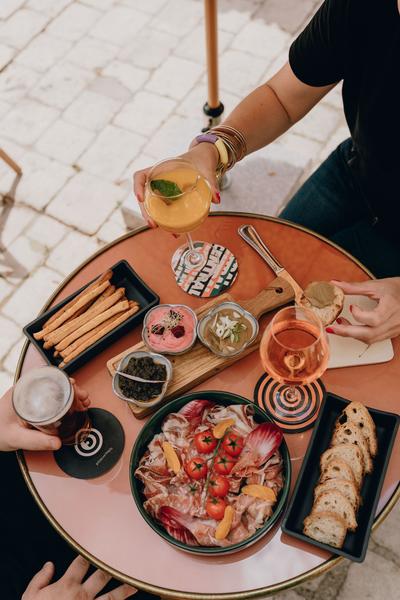 Un apéro avec des tapas à tremper, des tranches de saucisson, du vin, de la bière et du jus de fruits.
