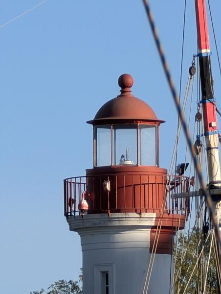 Le haut d'un phare rouge et blanc.