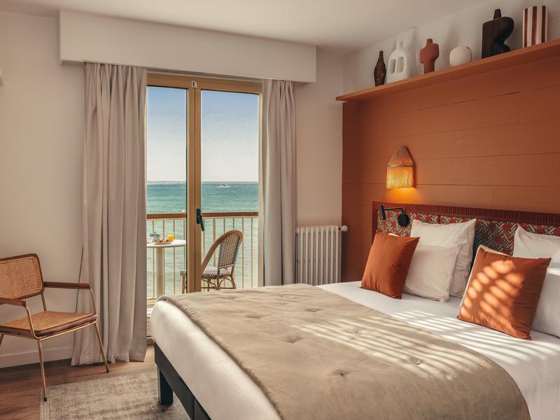 Chambre avec un lit double, avec vue sur l'océan.