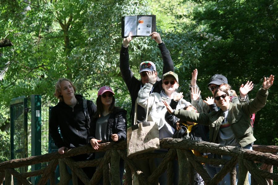 Une famille posant en photo sur un point, dans un parc.