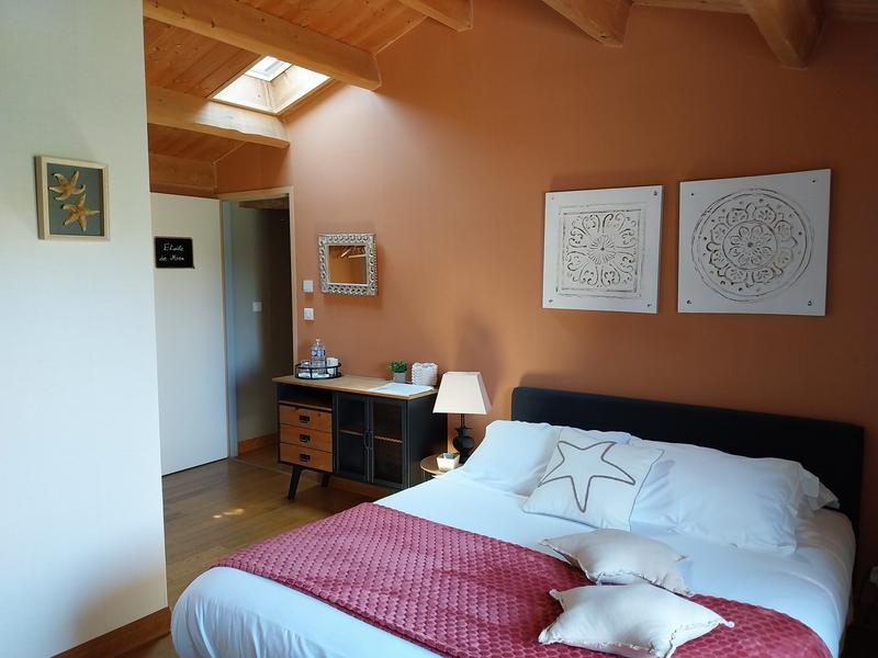 Une chambre orange sous le toit, avec un lit double.