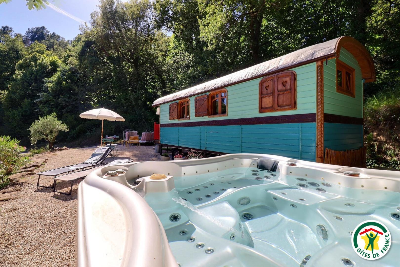 La roulotte vue de l'extérieur, avec le spa extérieur privatif