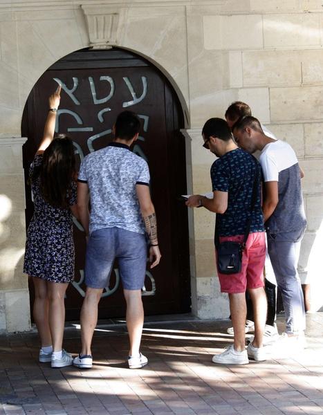 Un groupe de jeunes cherchant des indices devant une porte.