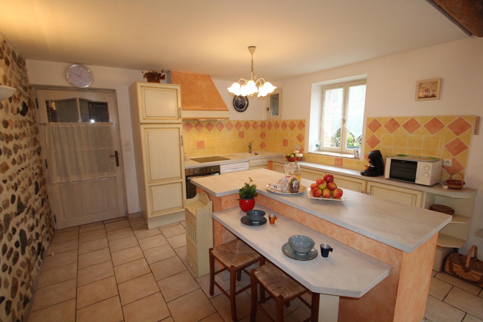 Coin cuisine, avec ilot et table attenante pour 2 personnes