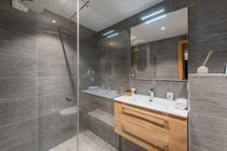 Salle de bains avec douche à l'italienne, grande vasque avec son meuble et grand miroir